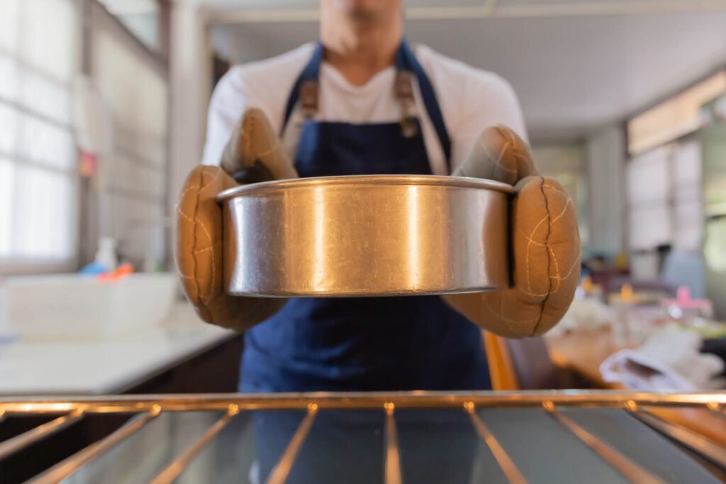 1920 male baker take cake out of a hot oven 1