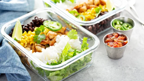 Healthy green mexican inspired meal prep with chicken, rice, beans, corn, salad