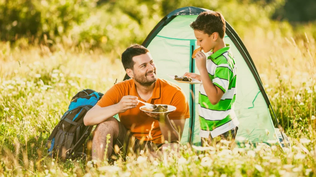 Man on Camping Holiday and cooking steak in pan